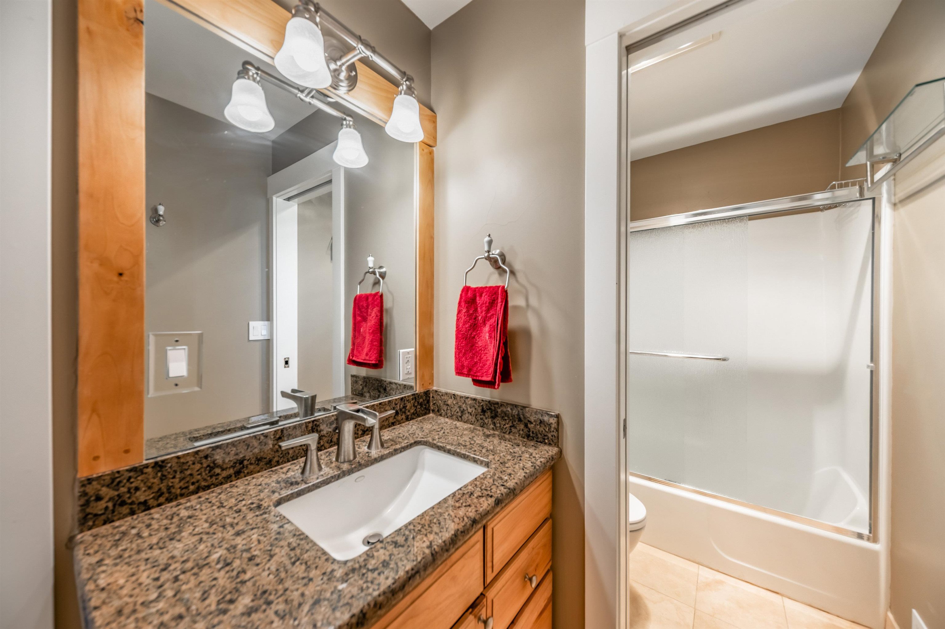 12957 Pinnacle Loop, Unit 6 Truckee, CA 96161 - Photo 18 of 28 a bathroom with a granite countertop tub shower and mirror
