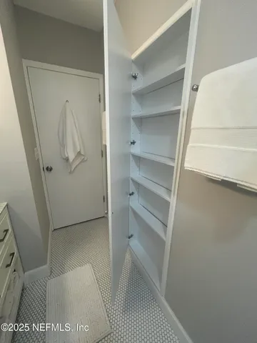 a bedroom with a bed a couch and a flat tv screen on the dresser