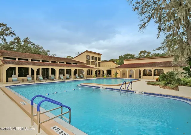 a sign of golf club on a wall under a tree