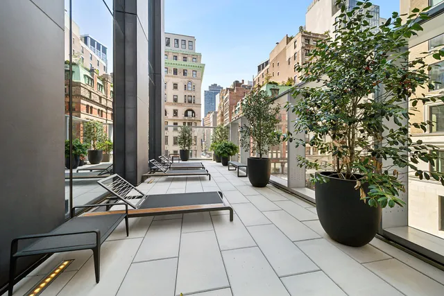 a view of a patio with table and chairs and potted plants