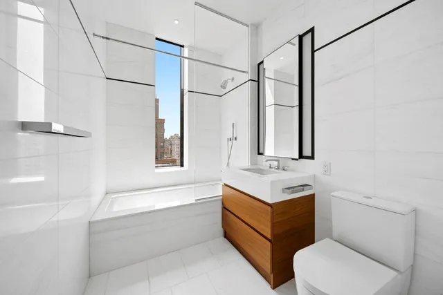 a bathroom with a sink vanity mirror bathtub shower and toilet