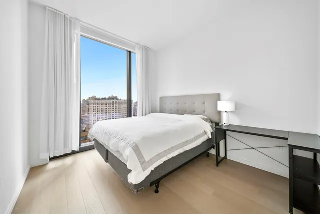 a bed sitting in a bedroom next to a window