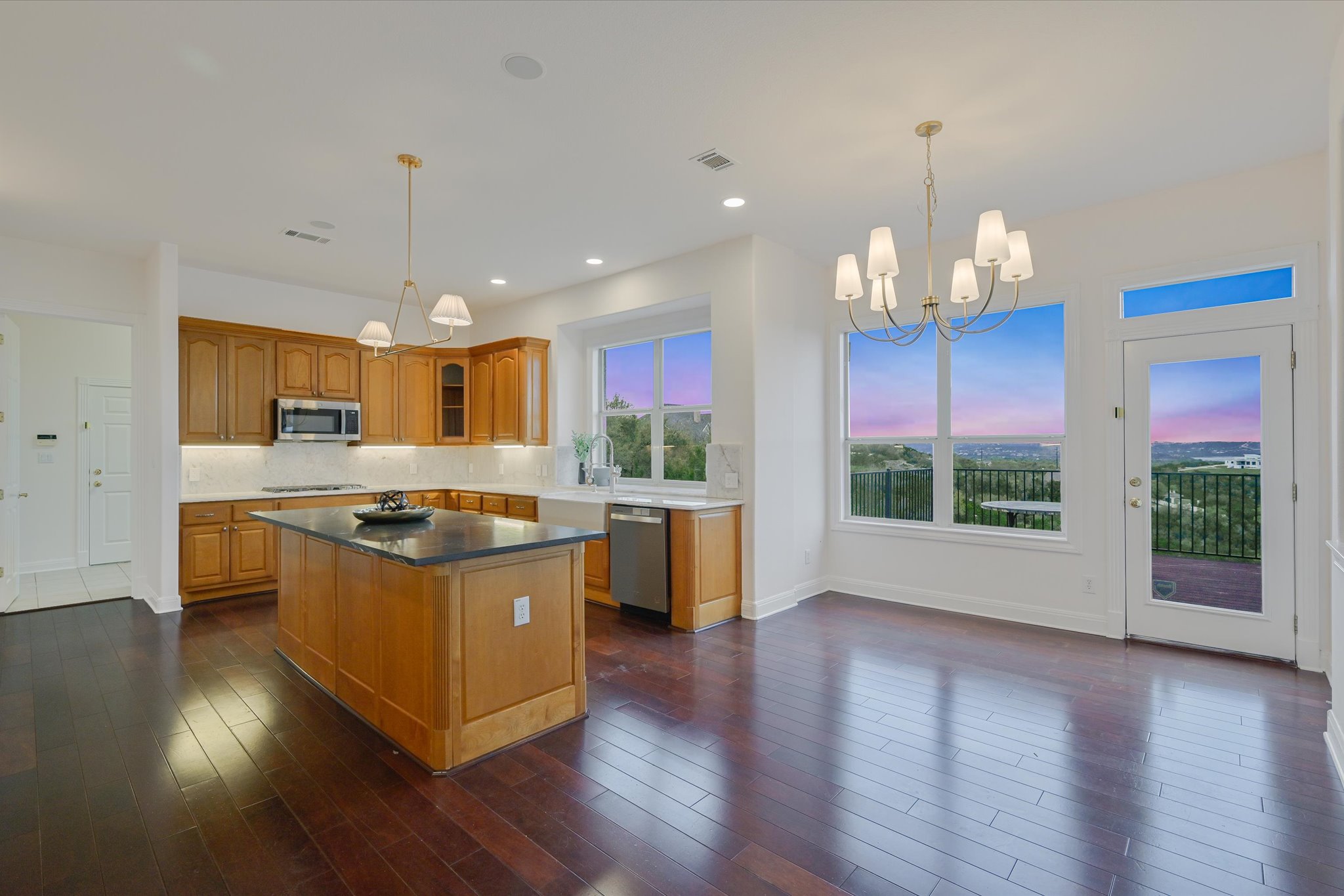 4319 Rum Runner Road Austin, TX 78734 - Photo 5 of 40 Kitchen & Breakfast area featuring a chandelier, wood finish cabinets, a kitchen island, decorative backsplash, and dark wood-style floors