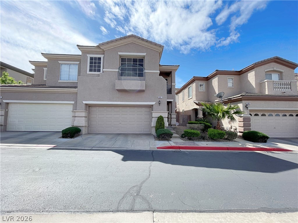 691 Principle Point Avenue Henderson, NV 89012 - Photo 2 of 30 Two-story stucco townhomes offer private garages and desert-friendly landscaping.