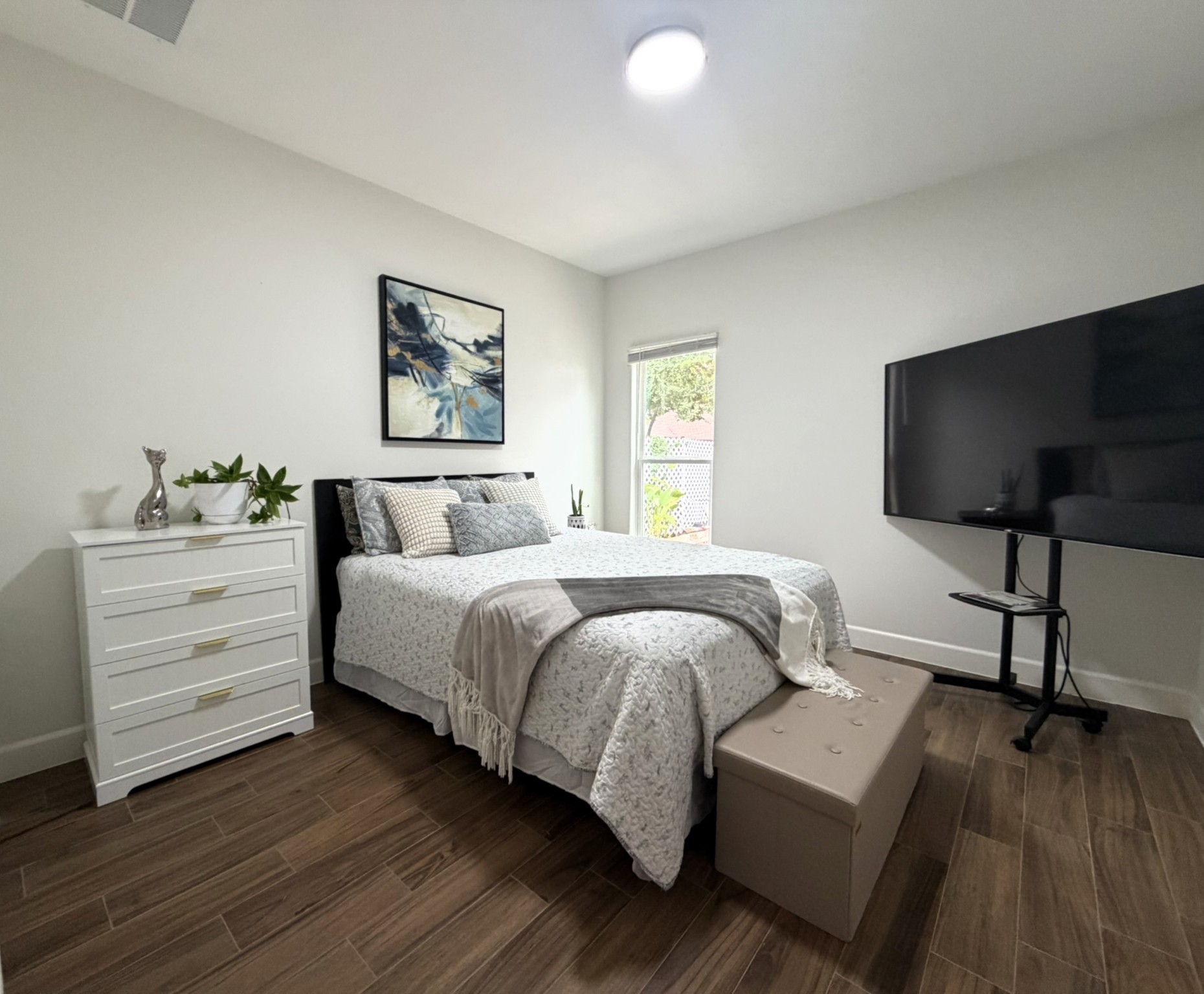 20602 Oak Ridge Lago Vista, TX 78645 - Photo 22 of 35 Rich wood-look flooring and a bright window elevate this comfortable bedroom space.