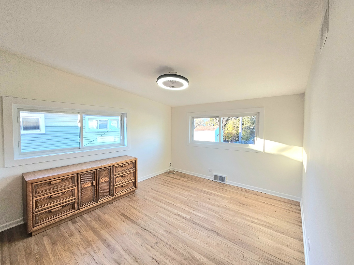 7434 Emerson Street Morton Grove, IL 60053 - Photo 17 of 38 a view of an empty room with window and wooden floor