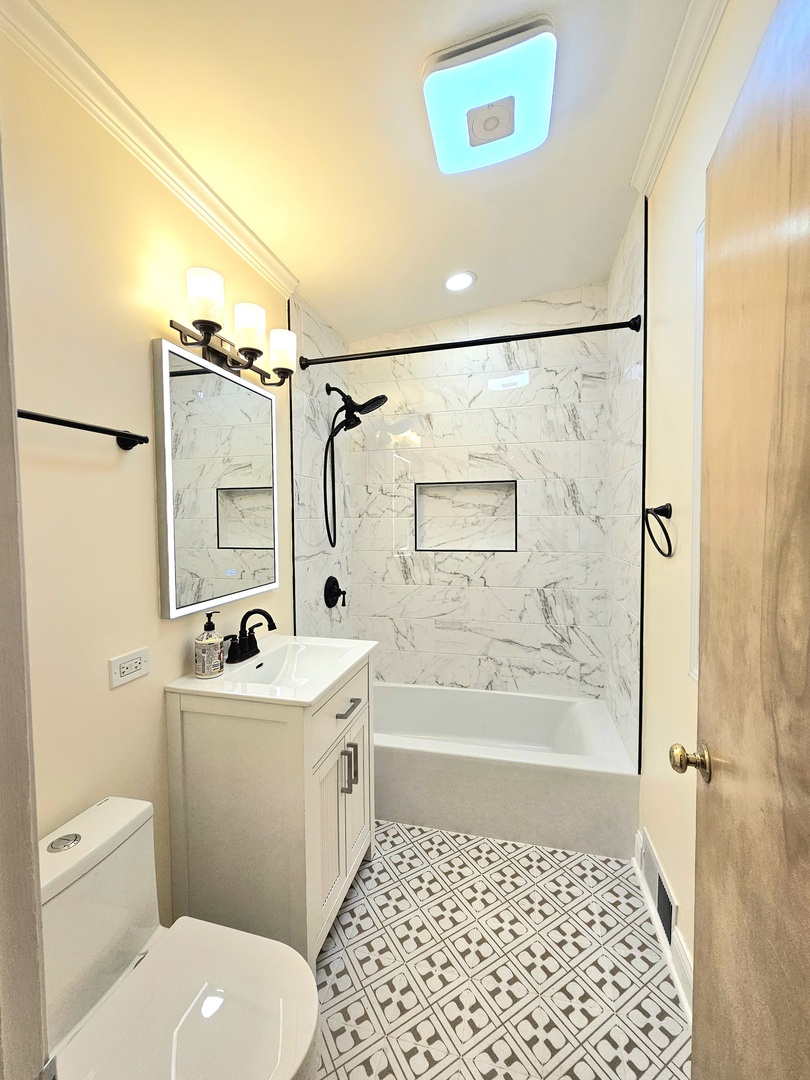 7434 Emerson Street Morton Grove, IL 60053 - Photo 23 of 38 a bathroom with a sink a toilet and shower