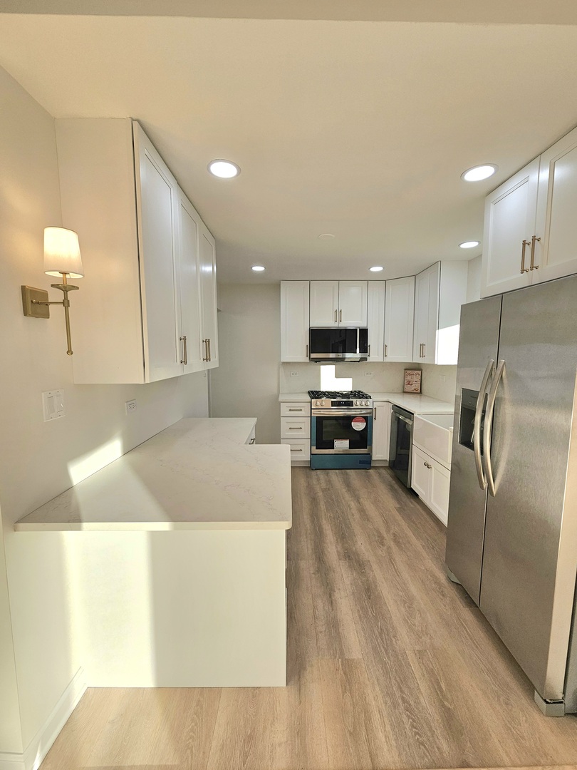 7434 Emerson Street Morton Grove, IL 60053 - Photo 7 of 38 a large kitchen with a large counter top appliances and cabinets