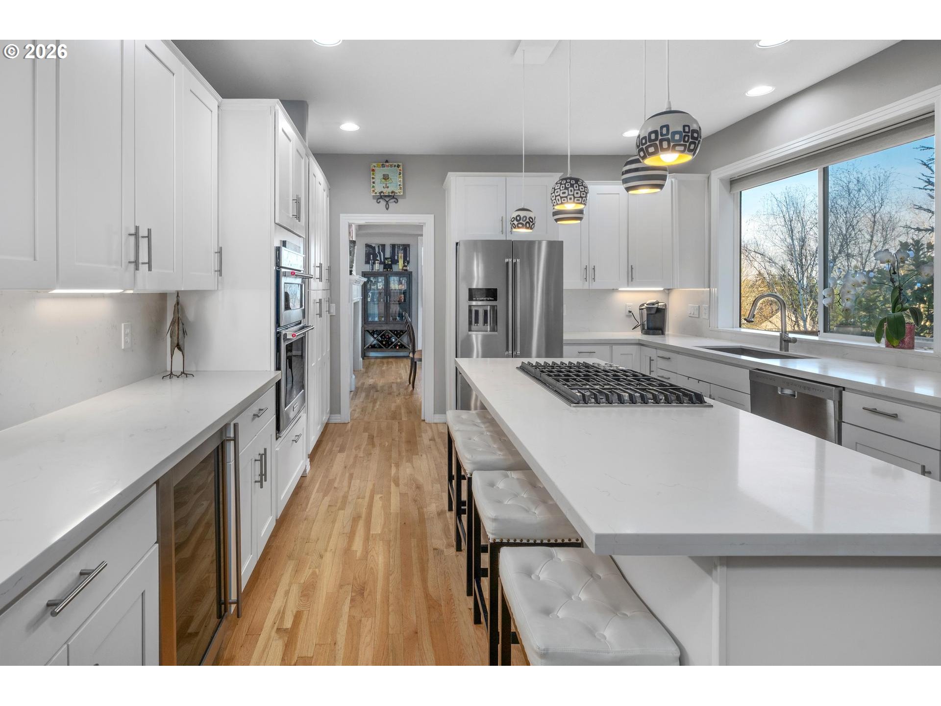 13072 Southwest Morningstar Drive Portland, OR 97223 - Photo 11 of 48 a open kitchen with stainless steel appliances granite countertop a refrigerator a sink dishwasher a stove and white countertops with wooden floor
