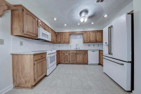 a large kitchen with stainless steel appliances granite countertop a stove a sink dishwasher and a refrigerator