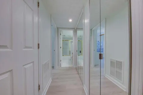 a view of a hallway with closet and bathroom