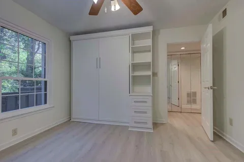 an empty room with windows and closet