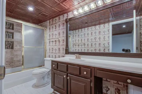a bathroom with a granite countertop sink a toilet and shower