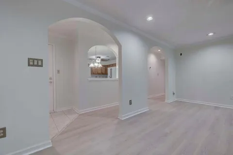 an empty room with windows and mirror