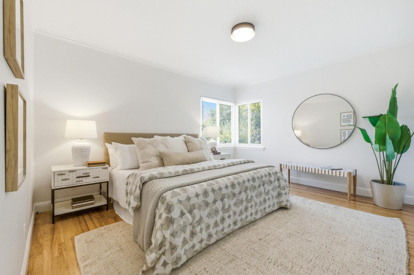 9858 Golf Links Road Oakland, CA 94605 - Photo 21 of 39 a bed room with a bed mirror and a potted plant