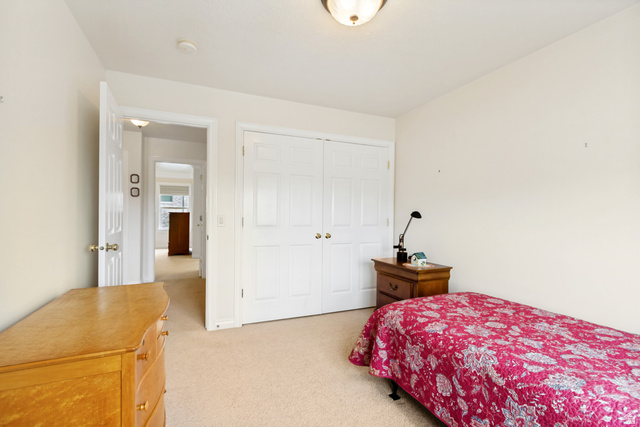 298 North Canyon Road Bountiful, UT 84010 - Photo 26 of 57 Neutral-toned carpeted room featuring a double-door closet with gold-finish hardware, a white paneled entry door, and light cream wall finishes