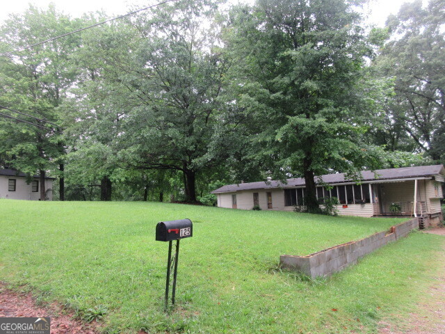 a view of a house with backyard and a hammock