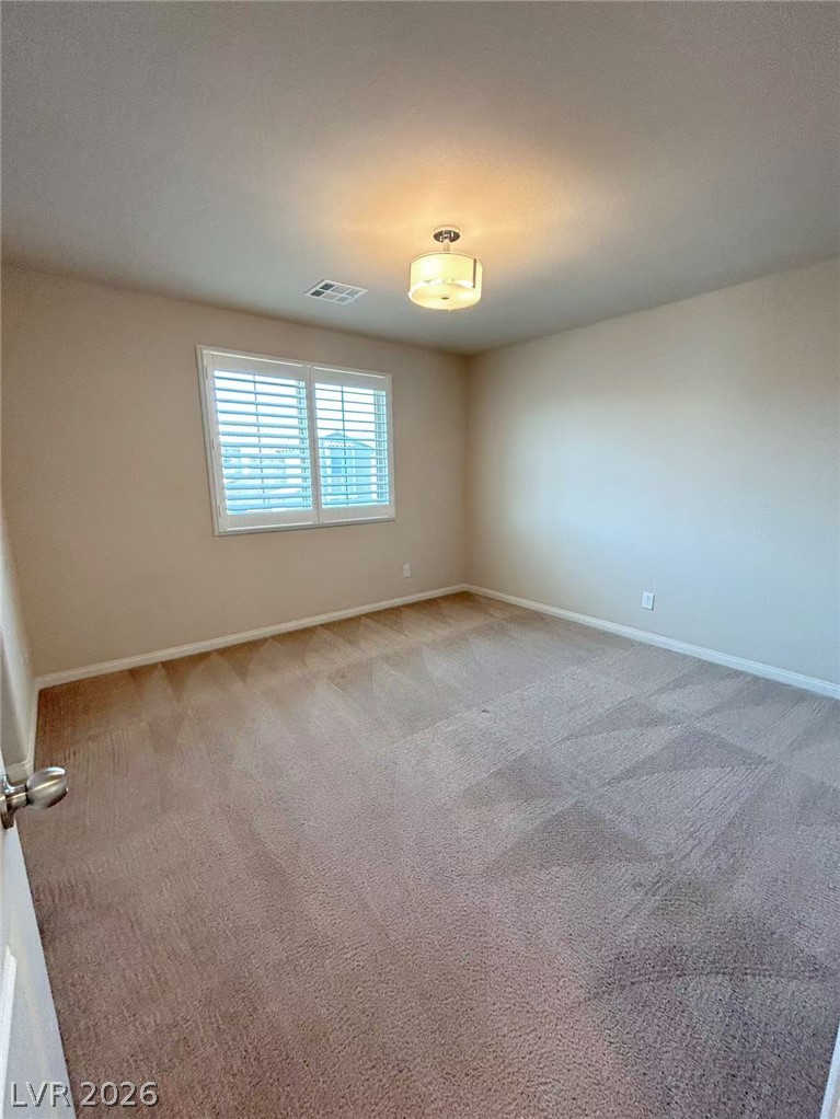 146 Tree Shot Court Las Vegas, NV 89113 - Photo 11 of 18 A well-lit bedroom features plush carpeting and a bright window with horizontal blinds.