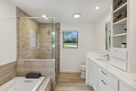 a bathroom with a sink a toilet and shower