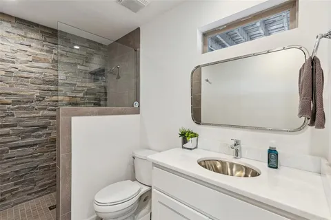 a bathroom with a toilet sink vanity and mirror