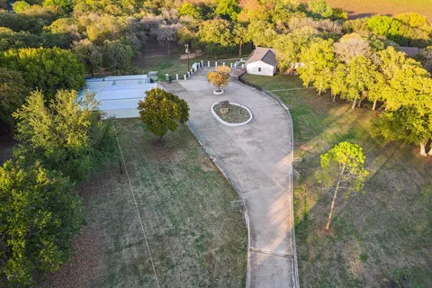 an aerial view of a house with swimming pool and outdoor seating