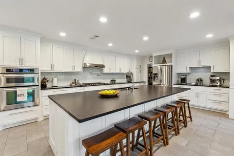 a kitchen with stainless steel appliances granite countertop a sink counter space and a refrigerator