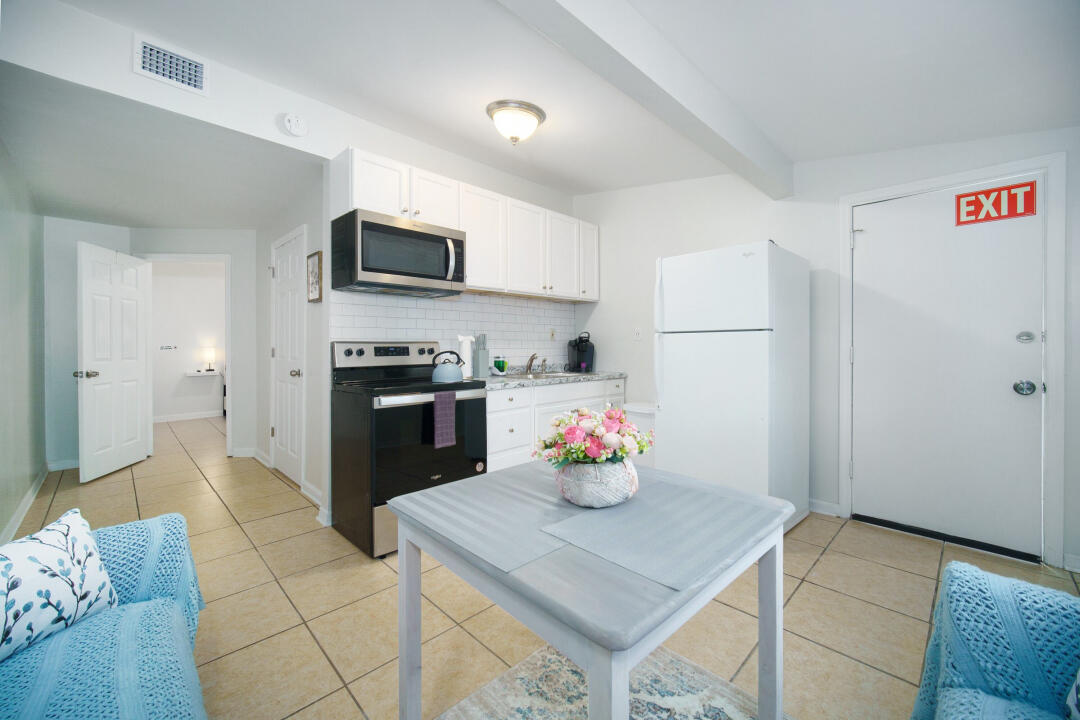 107 Lighthouse Road North Jacksonville, FL 32225 - Photo 35 of 43 a kitchen with stainless steel appliances kitchen island granite countertop a refrigerator a stove a microwave and a dining table with wooden floor
