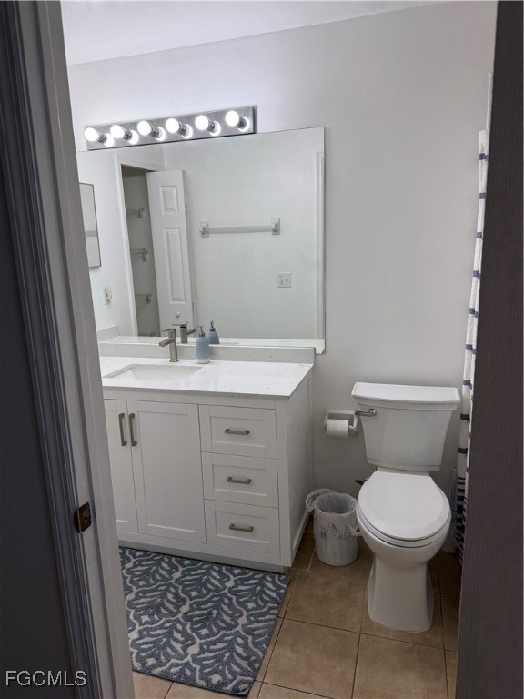 4621 30th Street Southwest Lehigh Acres, FL 33973 - Photo 5 of 8 a bathroom with a granite countertop toilet a sink and a mirror