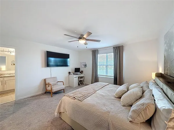 a bedroom with bed tv and window