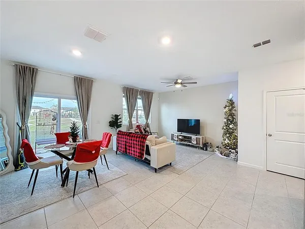 a living room with furniture a flat screen tv and large window