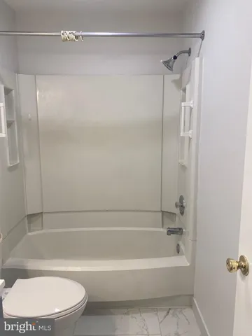 a bathroom with a toilet and a bathtub