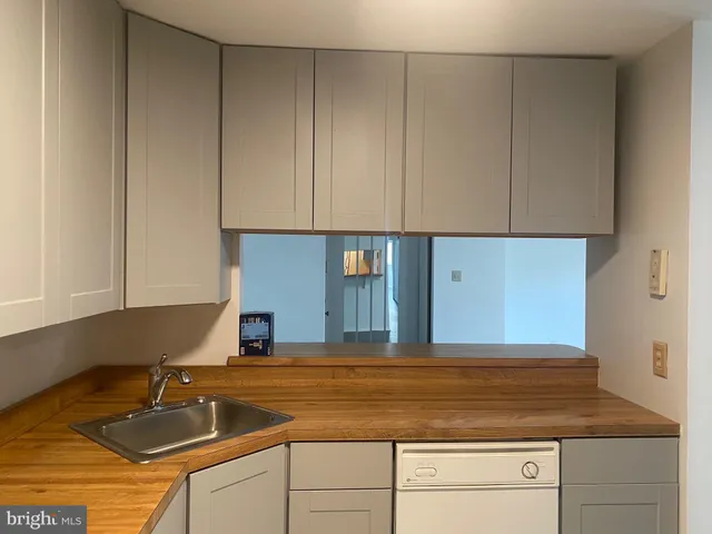 a kitchen with granite countertop a sink and white cabinets