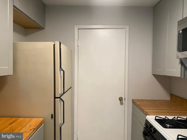 a kitchen with a refrigerator and a stove top oven