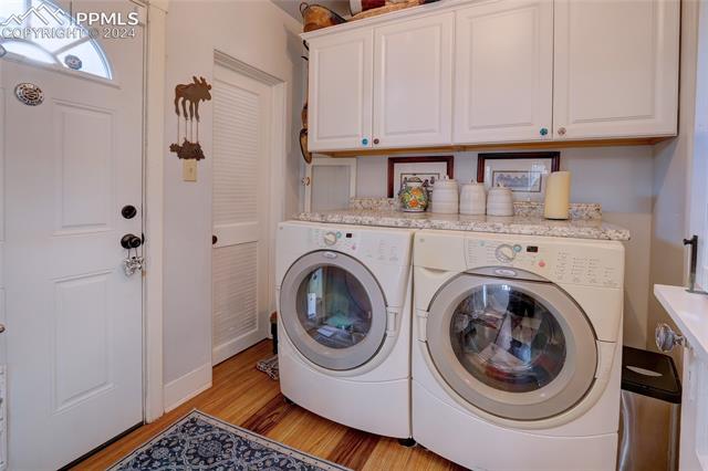 314 West Cheyenne Road Colorado Springs, CO 80906 - Photo 21 of 36 Clothes washing area with separate washer and dryer, light hardwood / wood-style flooring, and cabinets