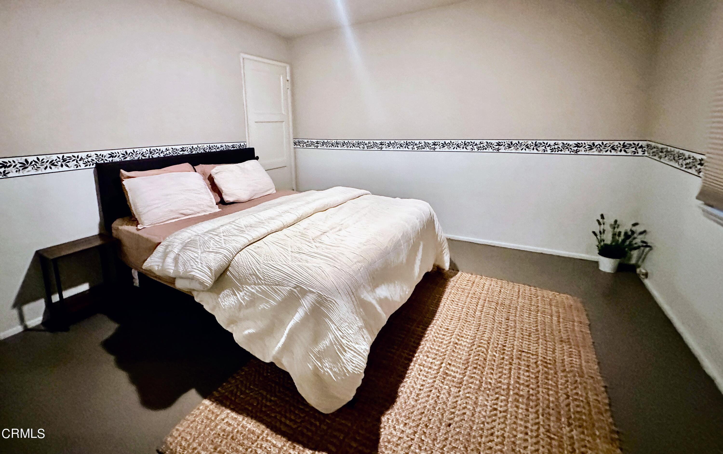 965 Jane Place Pasadena, CA 91105 - Photo 8 of 10 a bedroom with a bed rug and wooden floor