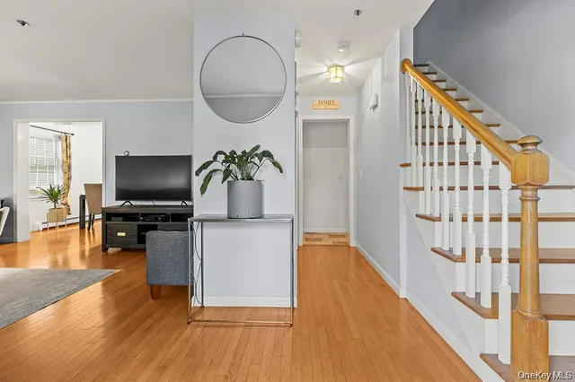 a living room with furniture mirror and wooden floor