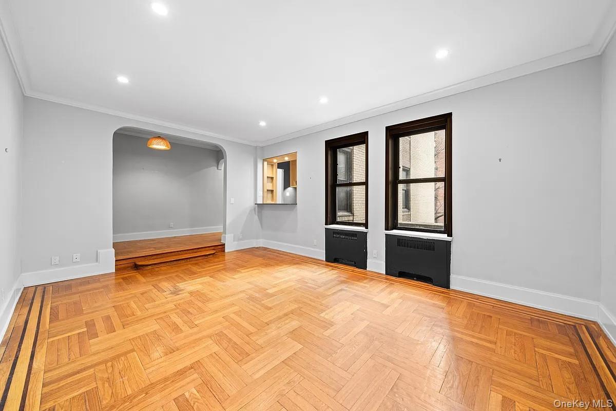 95 Park Terrace East, Unit 1D Manhattan, NY 10034 - Photo 4 of 20 Unfurnished room with arched walkways, recessed lighting, ornamental molding, and radiator heating unit