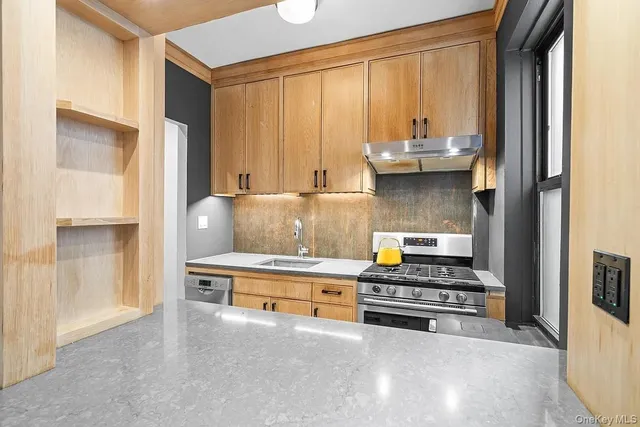 a kitchen with stainless steel appliances a stove and more cabinets