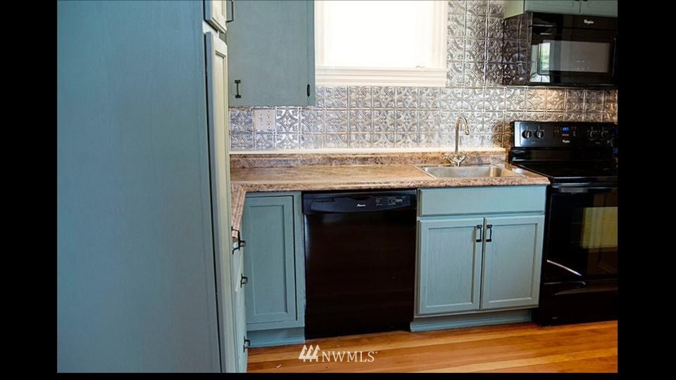 3302 Rucker Avenue Everett, WA 98201 - Photo 16 of 22 a kitchen with stainless steel appliances granite countertop a stove and a microwave
