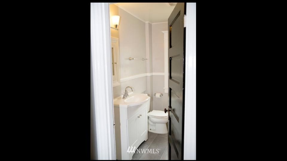 3302 Rucker Avenue Everett, WA 98201 - Photo 18 of 22 a bathroom with a granite countertop toilet and a picture of a bathroom