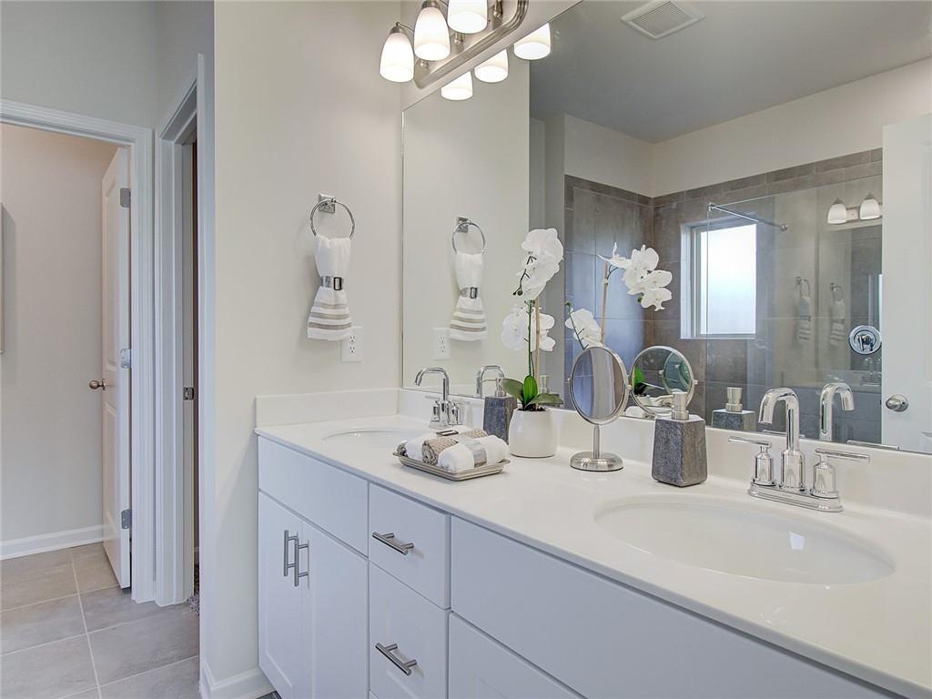486 Tallulah Lane Grayson, GA 30017 - Photo 11 of 17 a bathroom with double vanity sinks a vanity a lamp and a mirror