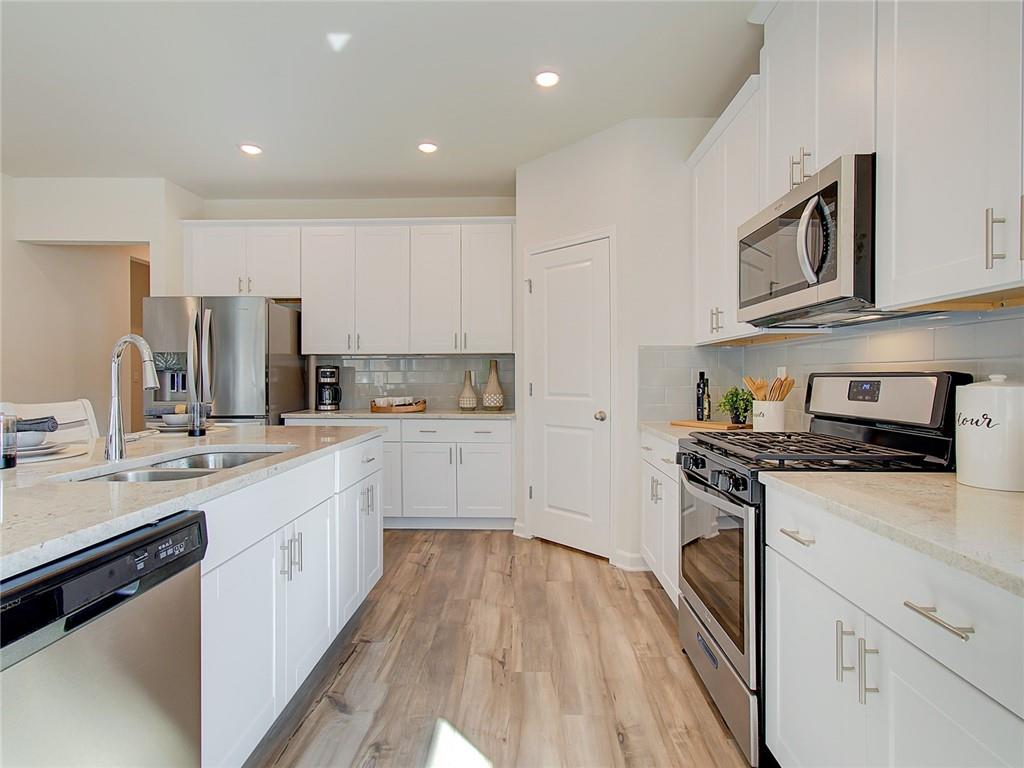 486 Tallulah Lane Grayson, GA 30017 - Photo 4 of 17 a kitchen with stainless steel appliances granite countertop a stove and a sink