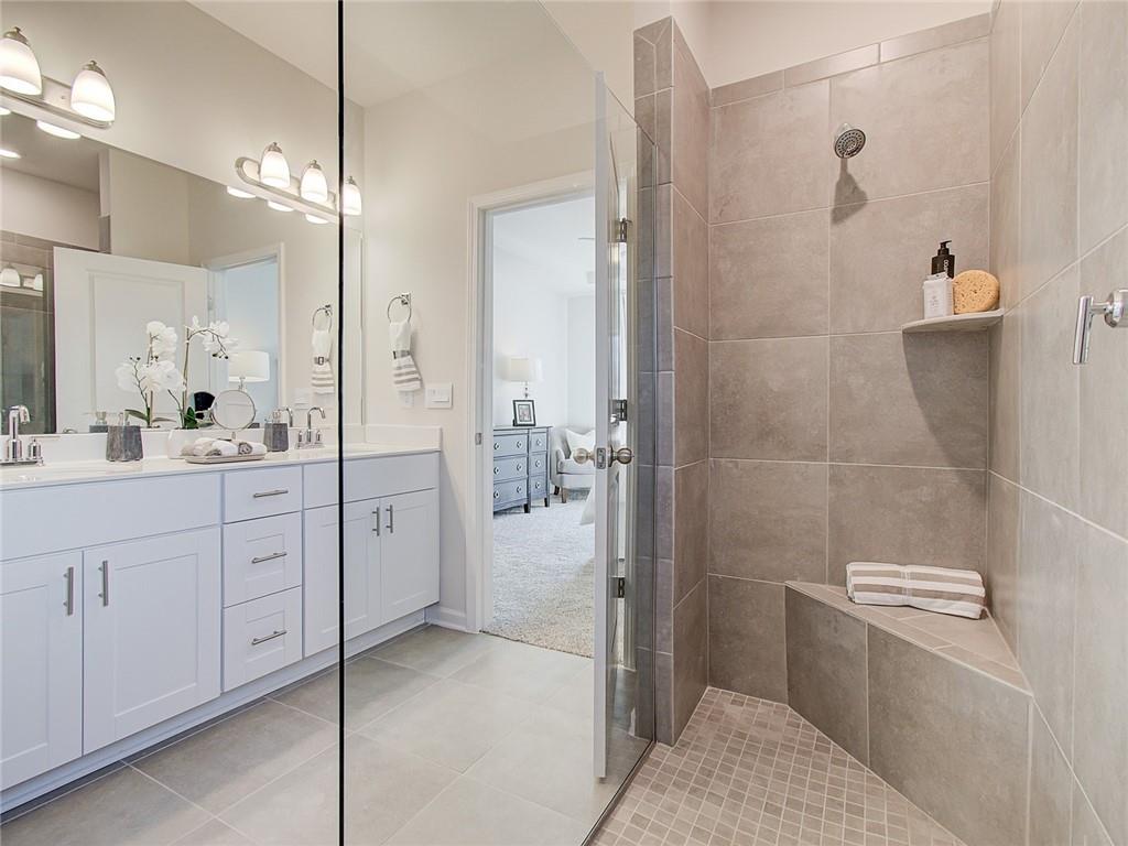 486 Tallulah Lane Grayson, GA 30017 - Photo 10 of 17 a bathroom with a granite countertop sink a toilet and shower