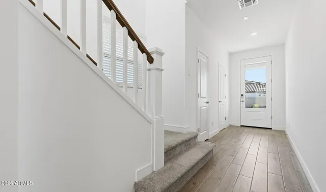 a view of a hallway with wooden floor and entryway