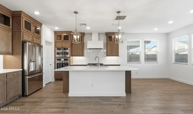 a kitchen with stainless steel appliances granite countertop a sink stove and refrigerator