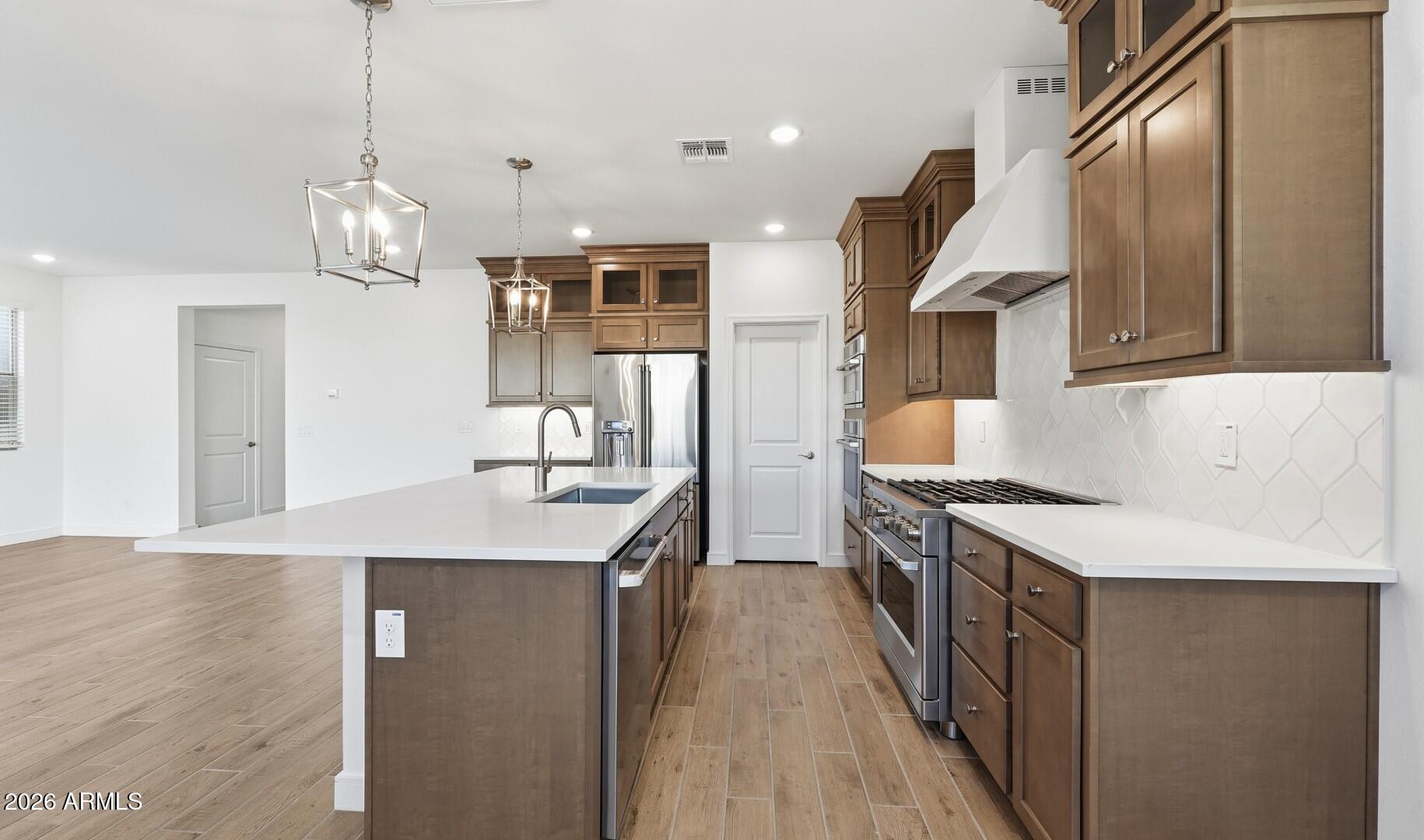 8010 West Royal Palm Road Peoria, AZ 85345 - Photo 3 of 34 a kitchen with a sink dishwasher a stove and a refrigerator with wooden floor