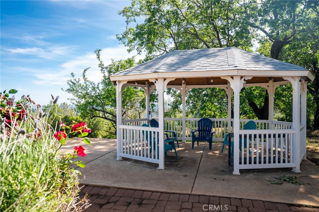 4620 Wendlis Road Forest Ranch, CA 95942 - Photo 37 of 50 a view of a deck with a table and chairs under an umbrella with a small yard