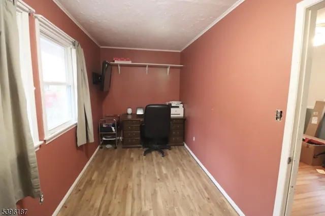 a view of a hallway with wooden floor and furniture