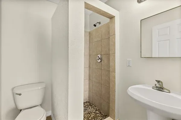 a bathroom with a sink a toilet and shower