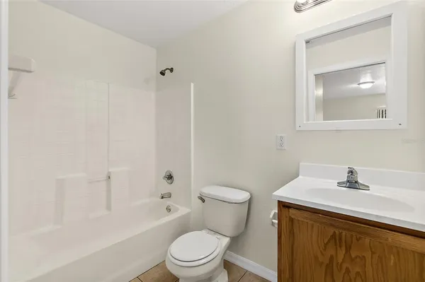 a view of an empty room and chandelier fan